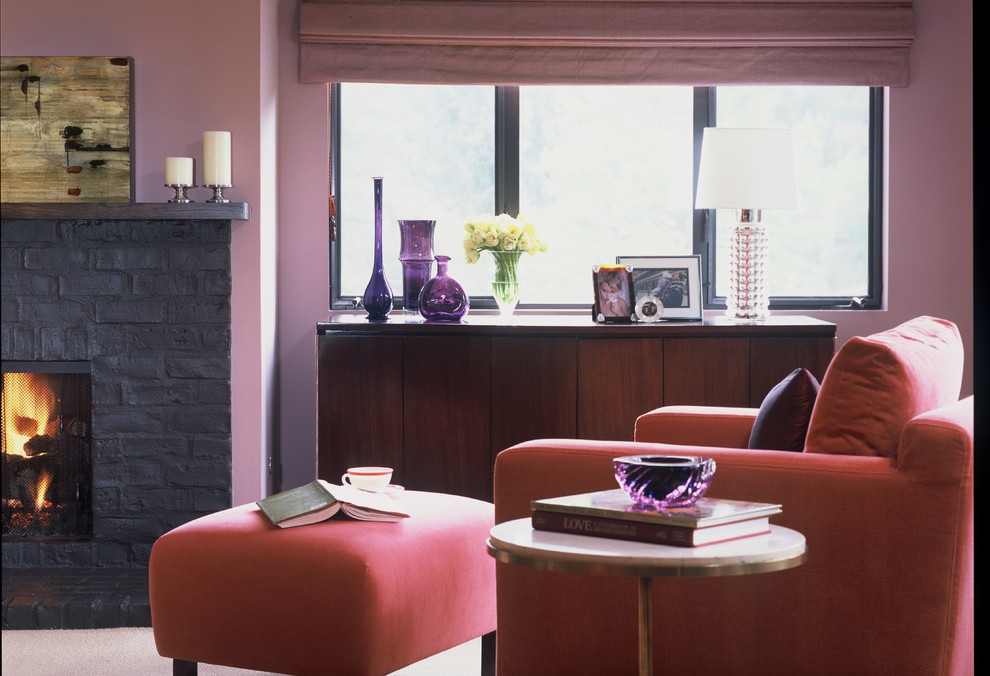 Foto på ett mellanstort funkis allrum med öppen planlösning, med ett finrum, rosa väggar, mörkt trägolv, en standard öppen spis och en spiselkrans i tegelsten