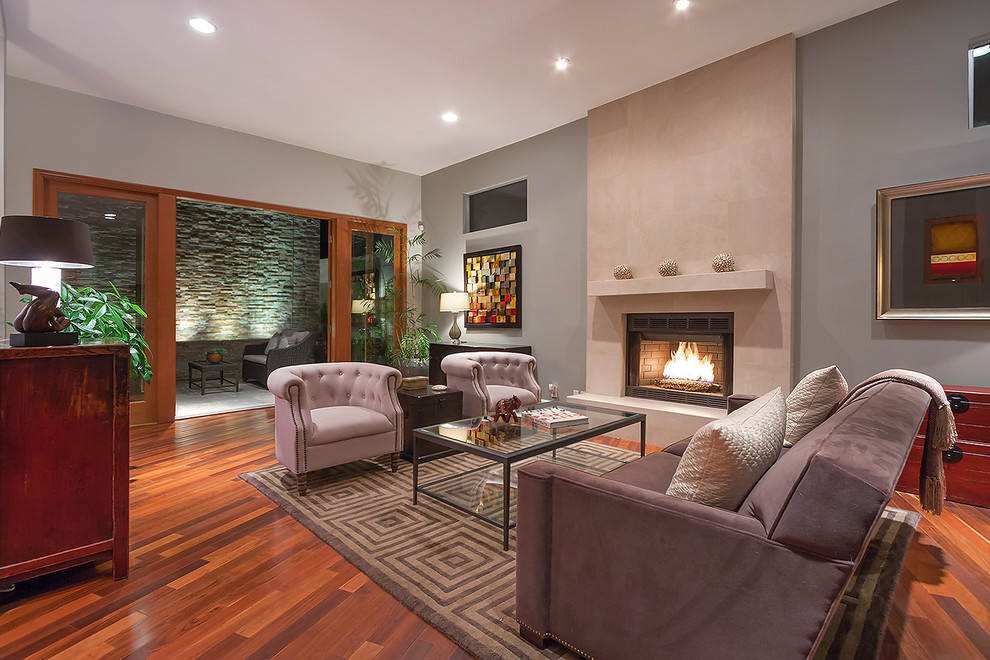 Repräsentatives Klassisches Wohnzimmer mit grauer Wandfarbe, braunem Holzboden und Kamin in Los Angeles