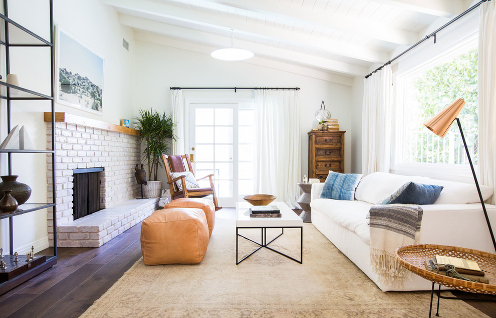 Cette photo montre un salon scandinave de taille moyenne et ouvert avec une salle de réception, un mur blanc, un sol en bois brun, une cheminée d'angle, un manteau de cheminée en brique, aucun téléviseur et un sol marron.