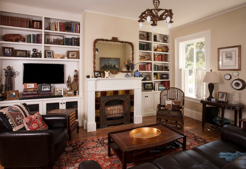 Klassisches Wohnzimmer mit beiger Wandfarbe, braunem Holzboden, Kamin, TV-Wand und braunem Boden in Seattle