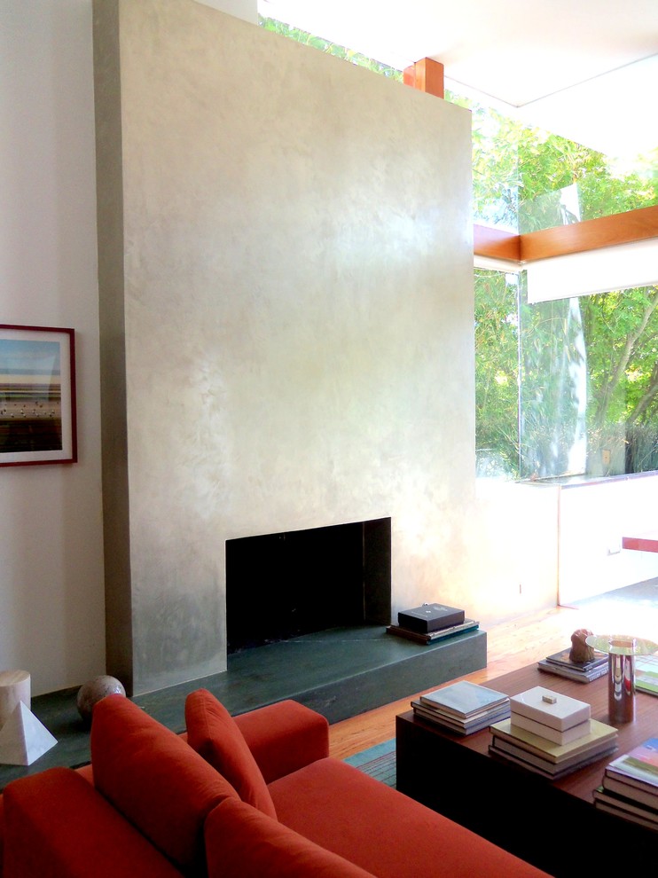 Immagine di un ampio soggiorno moderno aperto con libreria, pareti beige e parquet chiaro