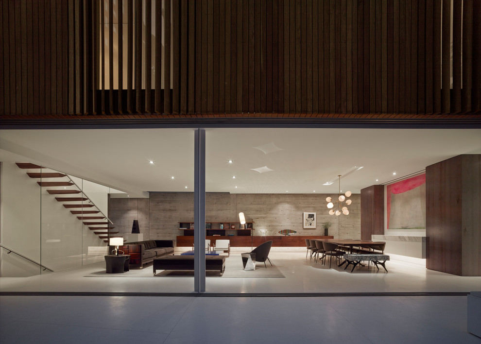 На фото: огромная открытая гостиная комната в стиле модернизм с серыми стенами