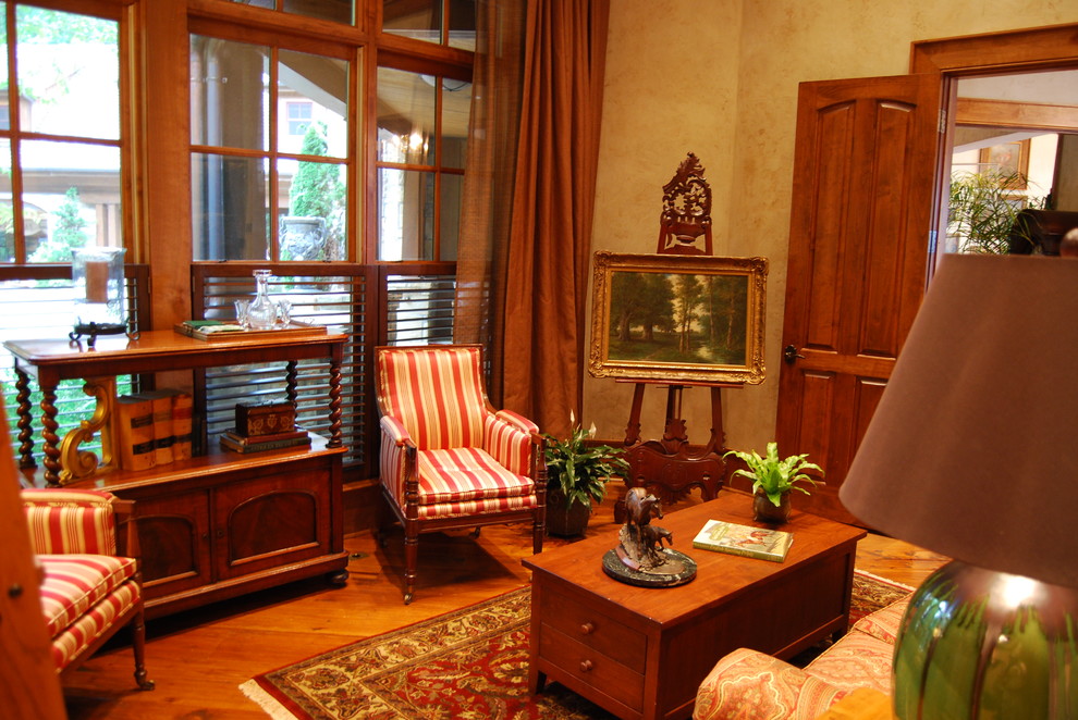 На фото: маленькая изолированная гостиная комната в классическом стиле с с книжными шкафами и полками, бежевыми стенами и паркетным полом среднего тона без камина, телевизора для на участке и в саду