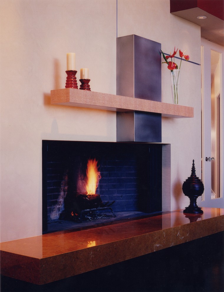 Inspiration pour un grand salon minimaliste avec parquet foncé, une cheminée standard et un manteau de cheminée en pierre.
