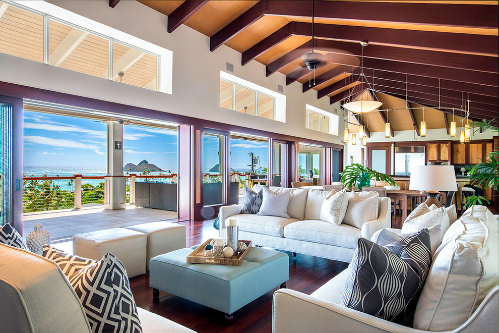 Offenes Maritimes Wohnzimmer mit weißer Wandfarbe und braunem Holzboden in Hawaii