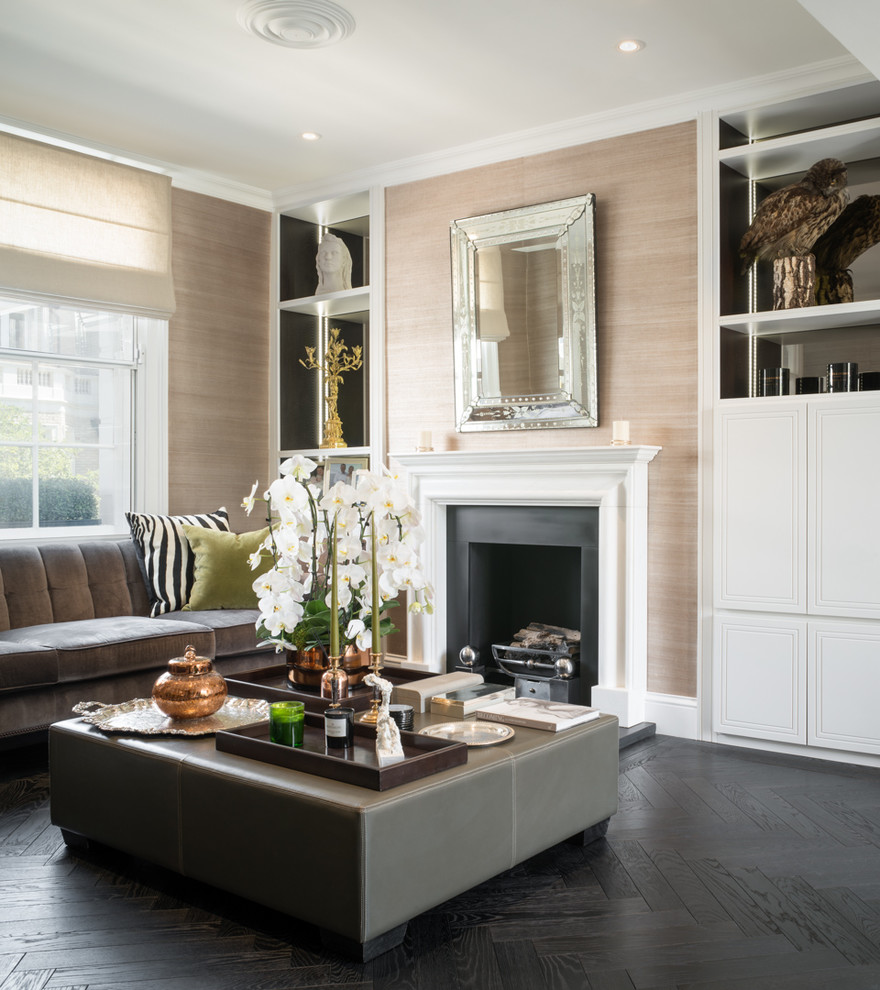 Abgetrenntes Klassisches Wohnzimmer mit beiger Wandfarbe, dunklem Holzboden, Kamin, Kaminumrandung aus Stein, Multimediawand und schwarzem Boden in London