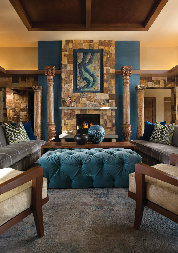Fernseherloses Modernes Wohnzimmer mit blauer Wandfarbe, Kaminumrandung aus Stein und Kamin in Albuquerque