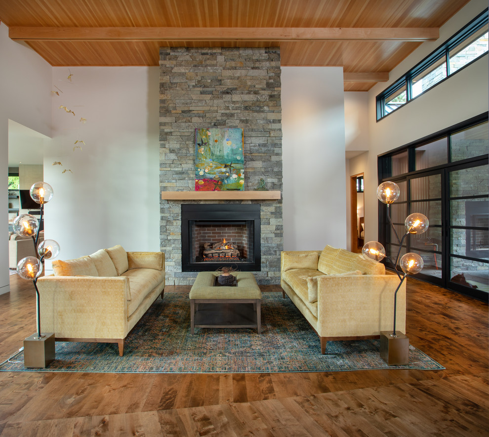 Large trendy open concept medium tone wood floor and brown floor living room photo in Other with white walls, a standard fireplace, a stone fireplace and no tv
