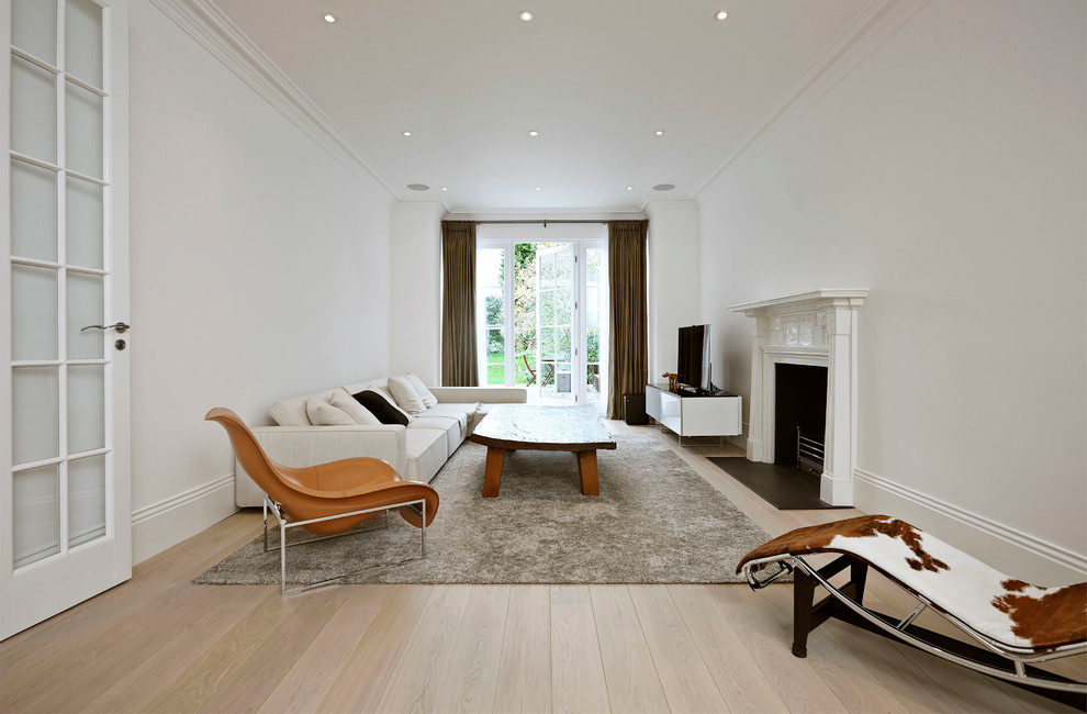 Living room - large scandinavian formal and enclosed light wood floor living room idea in London with white walls, a standard fireplace and a tv stand