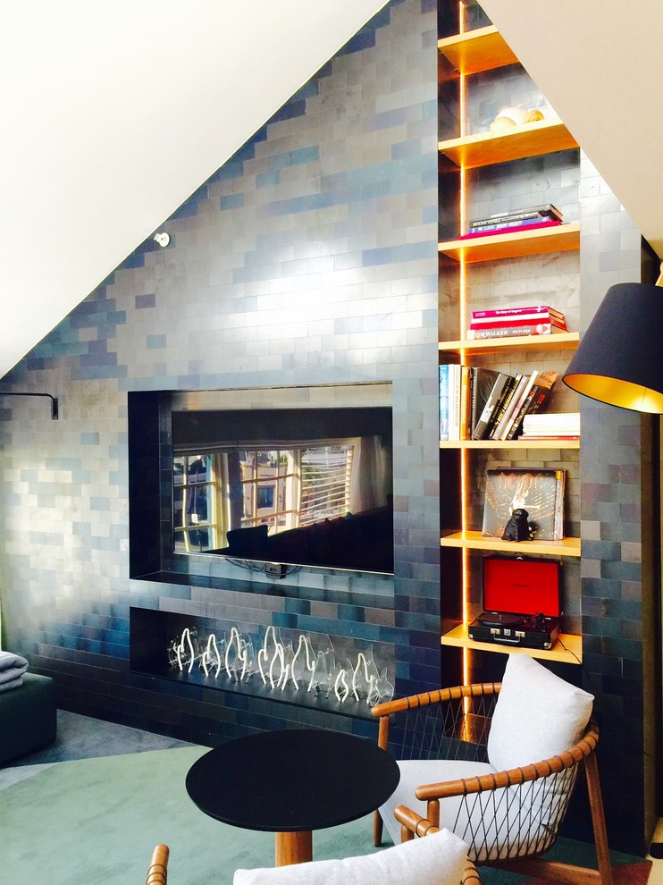 Foto di un piccolo soggiorno contemporaneo chiuso con libreria, pareti blu, moquette, camino lineare Ribbon, cornice del camino in metallo e TV a parete