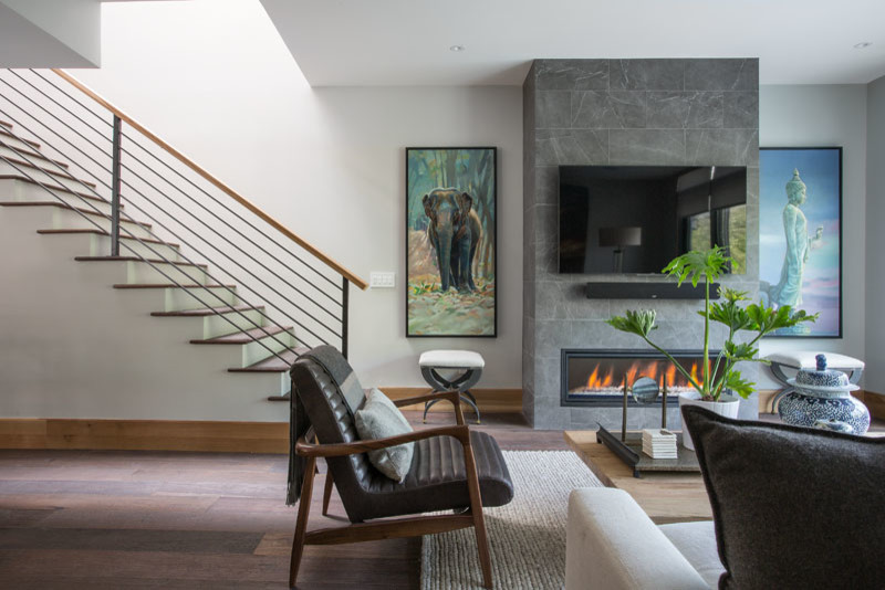 Example of a large minimalist formal and open concept medium tone wood floor and brown floor living room design in Salt Lake City with white walls, a hanging fireplace, a tile fireplace and a wall-mounted tv