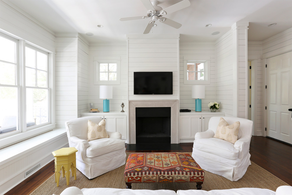 Maritimes Wohnzimmer mit weißer Wandfarbe, dunklem Holzboden, Kamin und TV-Wand in Charleston