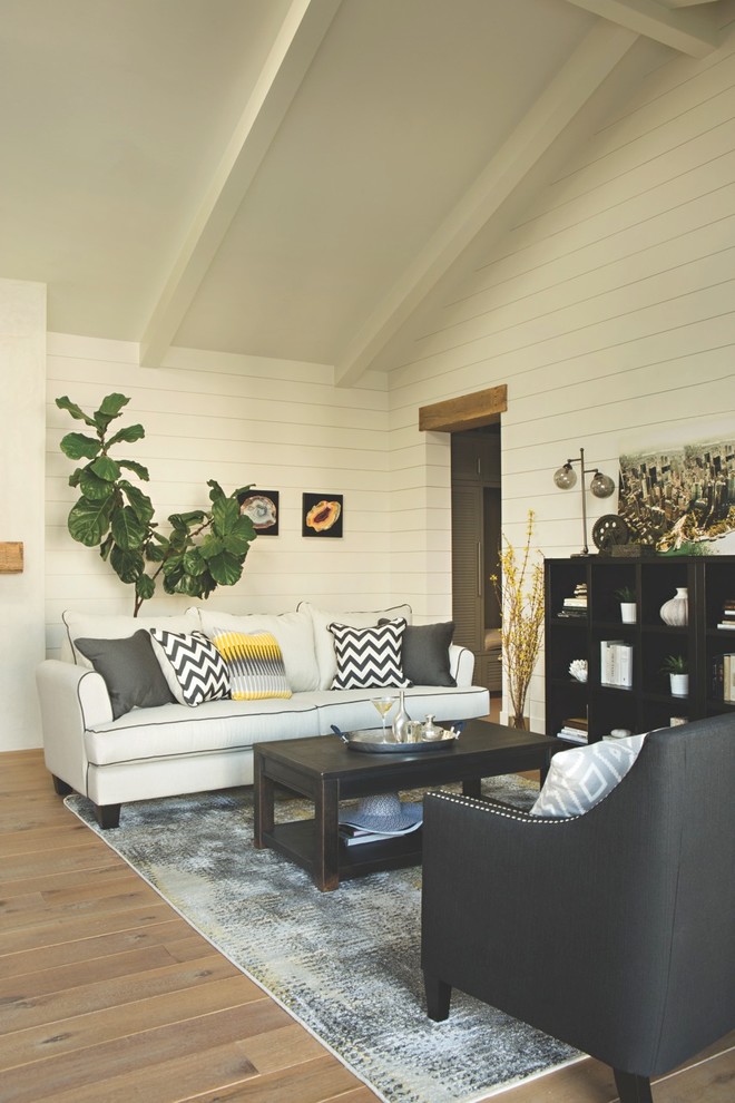 Modelo de salón cerrado actual de tamaño medio sin chimenea y televisor con paredes blancas y suelo de madera en tonos medios