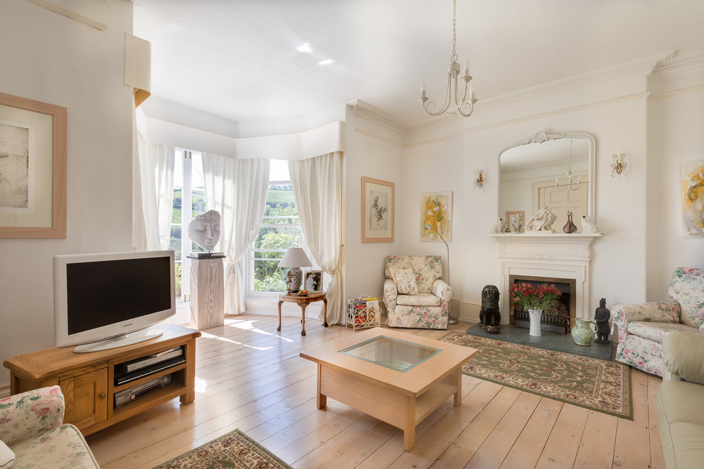 Großes, Repräsentatives, Abgetrenntes Klassisches Wohnzimmer mit weißer Wandfarbe, braunem Holzboden, Kamin und freistehendem TV in Devon