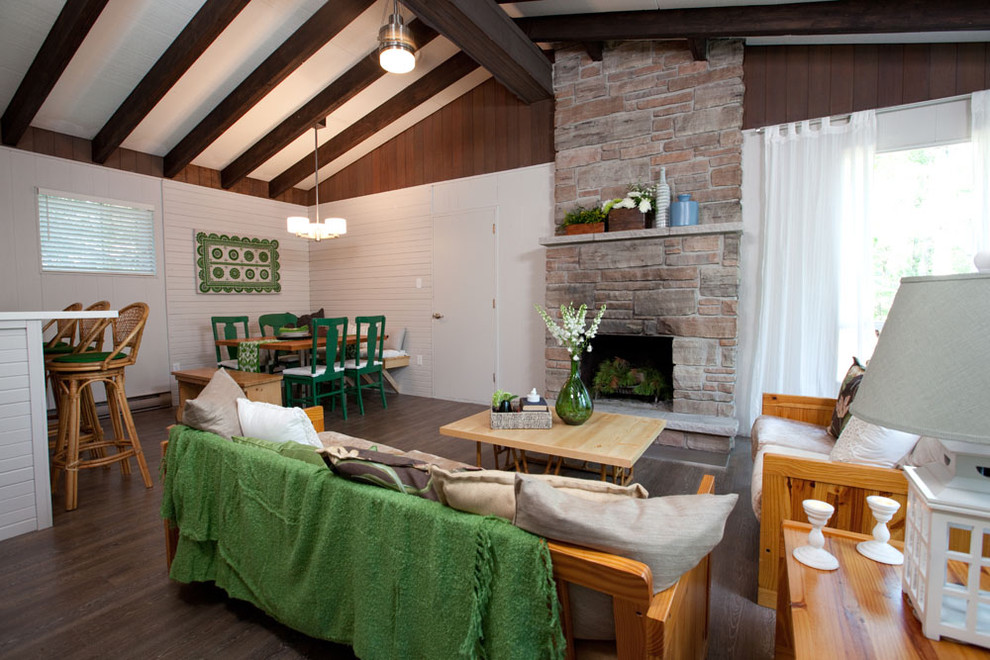 Cette photo montre un salon tendance ouvert avec une cheminée standard et un manteau de cheminée en pierre.