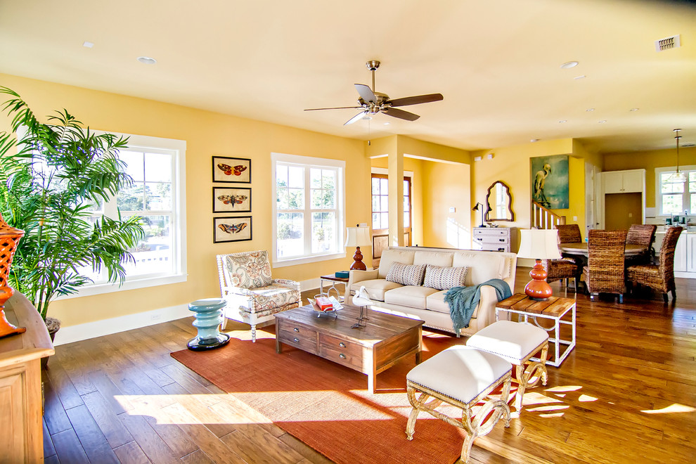 Offenes, Mittelgroßes, Fernseherloses Maritimes Wohnzimmer mit gelber Wandfarbe und dunklem Holzboden in Jacksonville