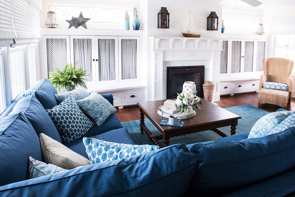 Living room - mid-sized coastal open concept medium tone wood floor and brown floor living room idea in Burlington with white walls, a standard fireplace, a tile fireplace and a concealed tv
