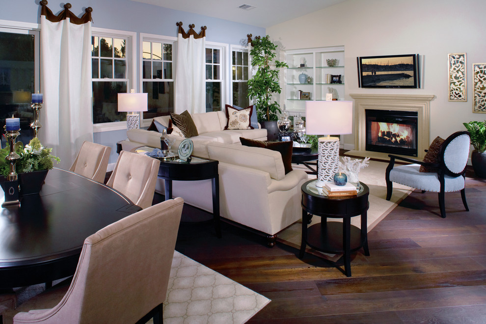 Esempio di un grande soggiorno chic aperto con pareti blu, pavimento in legno massello medio e TV a parete