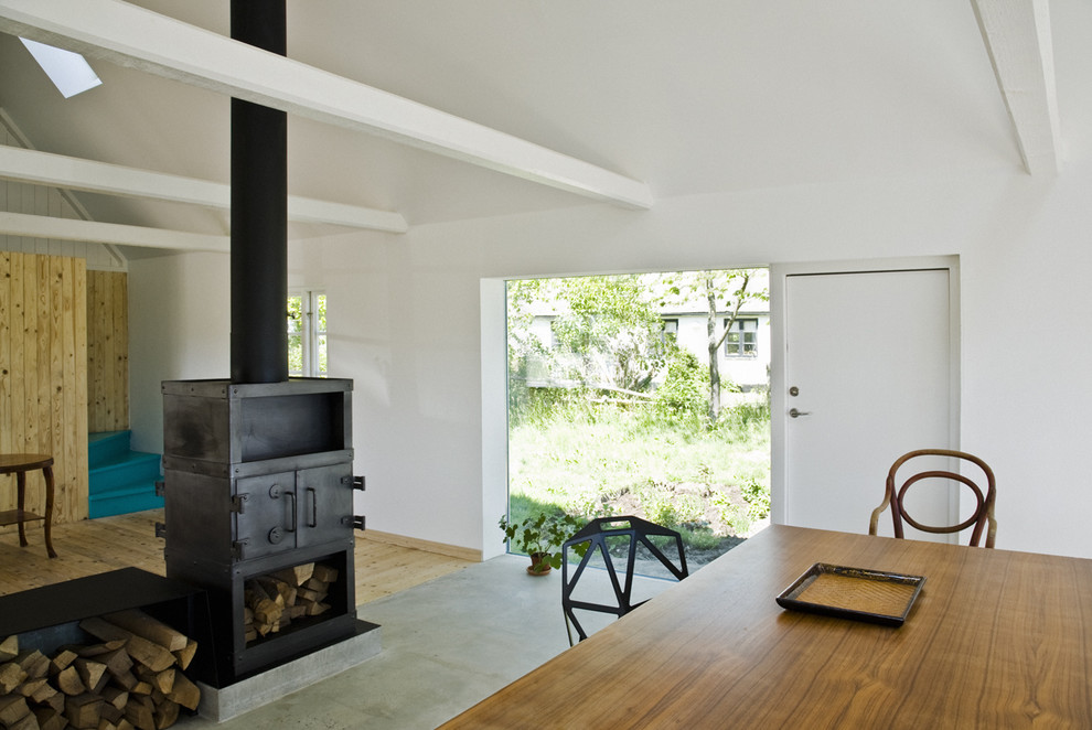 Example of a danish concrete floor living room design in Copenhagen with a wood stove