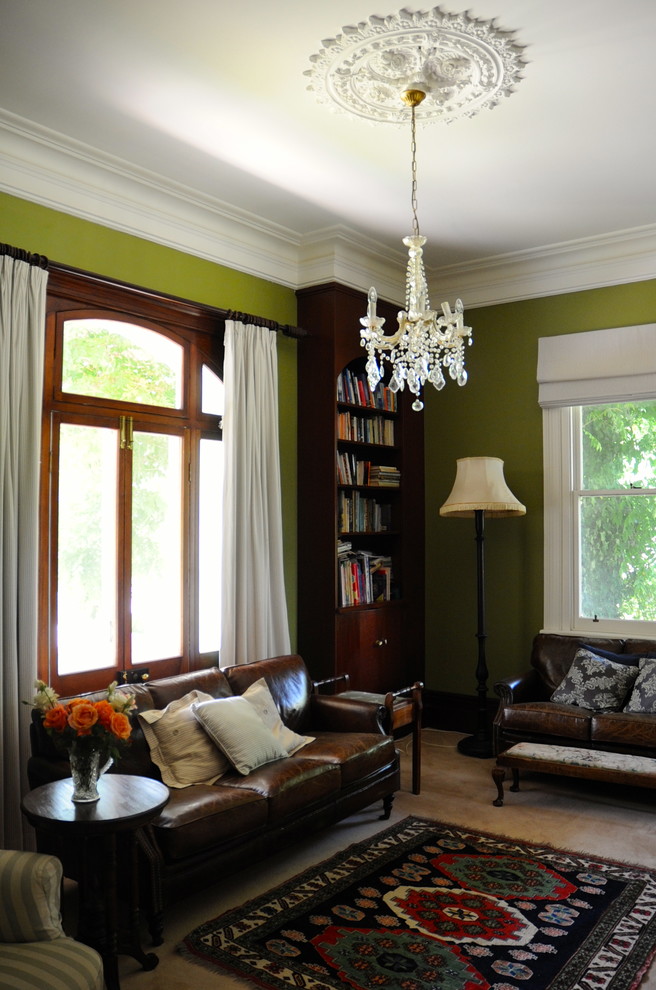 Стильный дизайн: гостиная комната:: освещение в классическом стиле с с книжными шкафами и полками и зелеными стенами - последний тренд