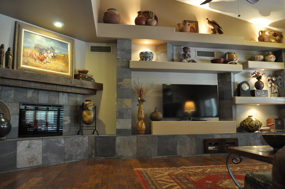 Mittelgroßes, Offenes Uriges Wohnzimmer mit beiger Wandfarbe, dunklem Holzboden, Eckkamin, Kaminumrandung aus Stein und freistehendem TV in Phoenix