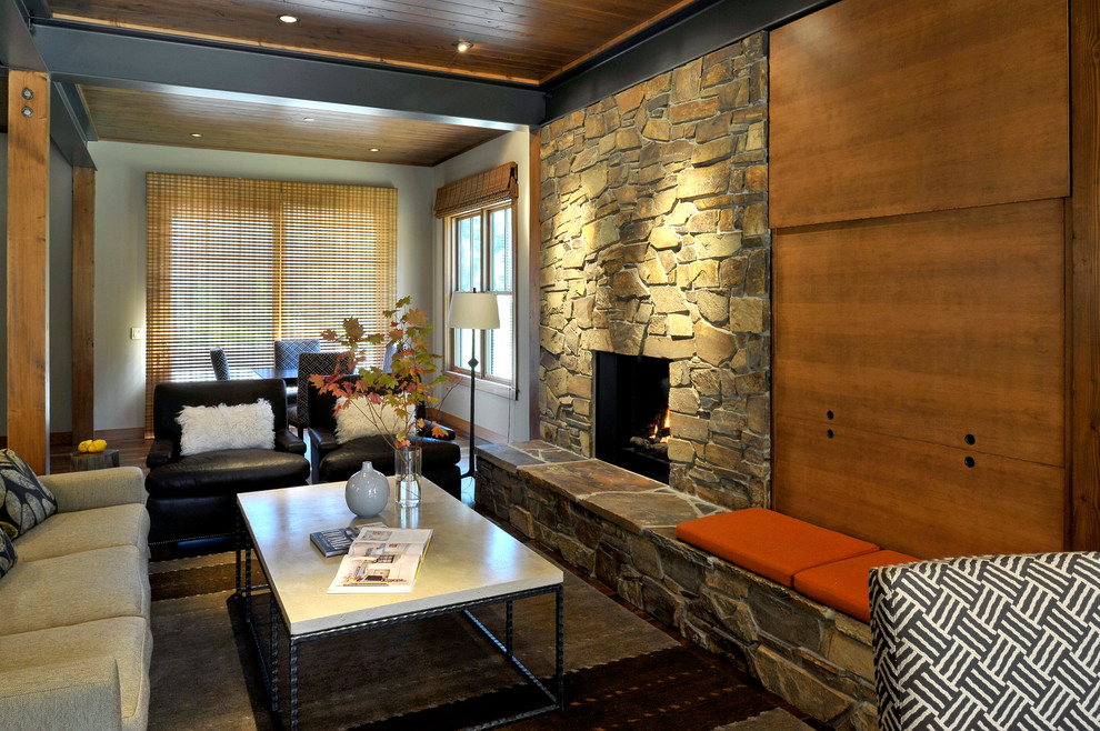 Exemple d'un salon tendance ouvert avec un manteau de cheminée en pierre et un téléviseur dissimulé.
