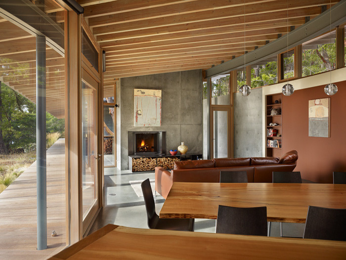 Стильный дизайн: открытая гостиная комната в современном стиле с серыми стенами, бетонным полом, стандартным камином и фасадом камина из бетона без телевизора - последний тренд