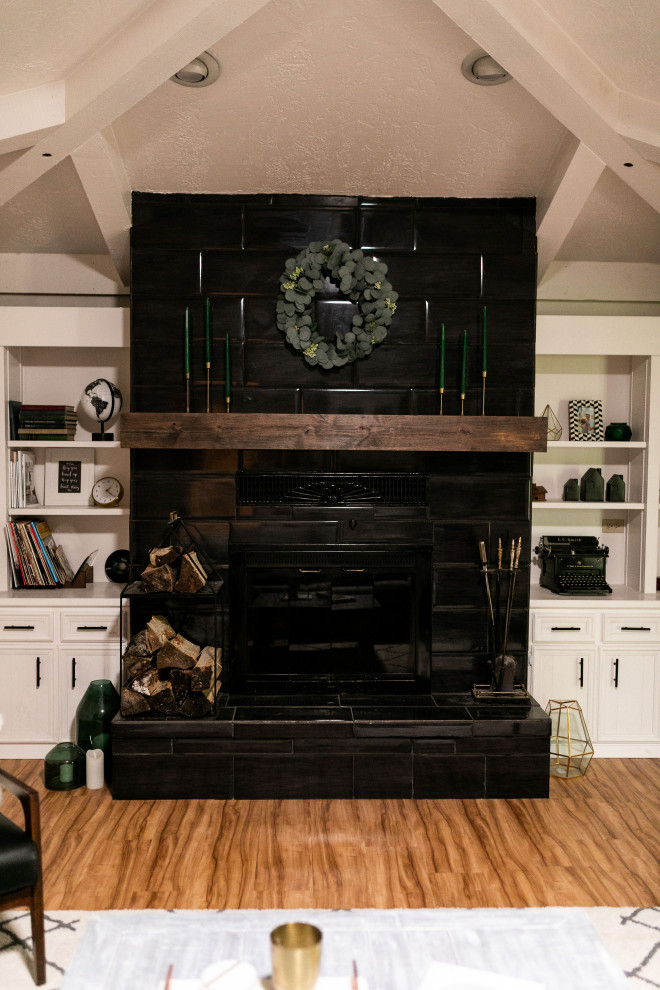 ソルトレイクシティにあるお手頃価格の中くらいなトラディショナルスタイルのおしゃれなLDK (ライブラリー、吊り下げ式暖炉、タイルの暖炉まわり、茶色い床、表し梁、板張り壁) の写真