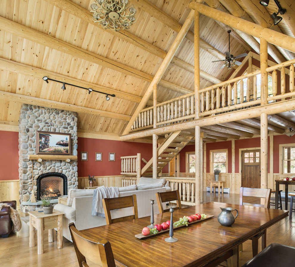 Esempio di un grande soggiorno rustico stile loft con pareti rosse, pavimento in legno massello medio, camino classico e cornice del camino in pietra