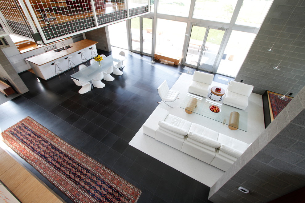 Свежая идея для дизайна: открытая гостиная комната в стиле лофт с ковром на полу - отличное фото интерьера