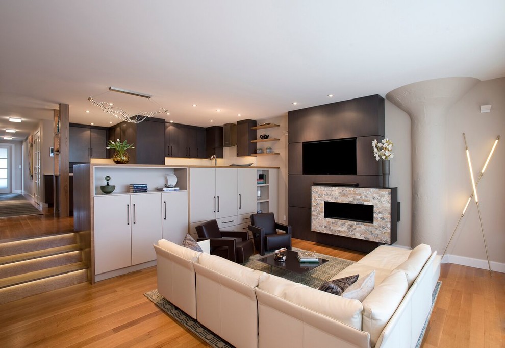 Photo of a medium sized contemporary open plan living room in Boston with grey walls, medium hardwood flooring, a hanging fireplace, a tiled fireplace surround, a built-in media unit and brown floors.