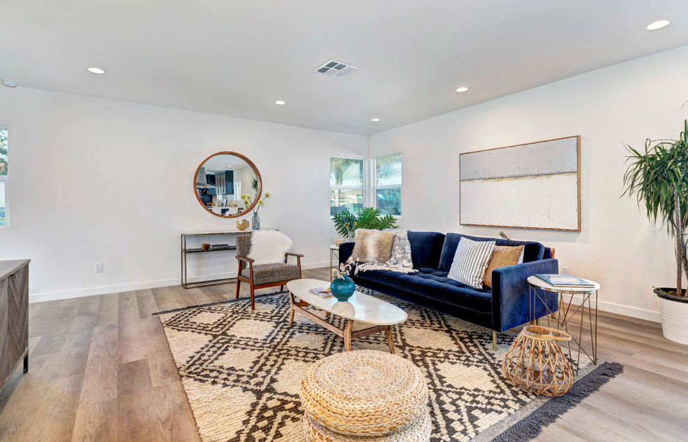 Immagine di un soggiorno chic con pareti bianche, pavimento in legno massello medio e pavimento marrone
