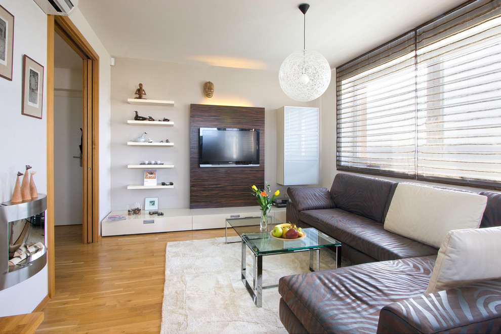 Abgetrenntes Modernes Wohnzimmer mit braunem Holzboden und TV-Wand in Sonstige