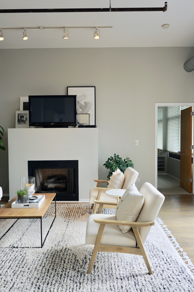 This is an example of a small retro living room in Chicago with grey walls and a freestanding tv.