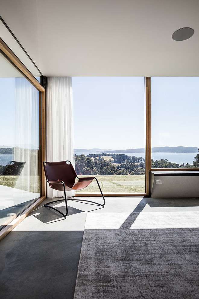 Cette image montre un salon minimaliste avec sol en béton ciré et un sol gris.