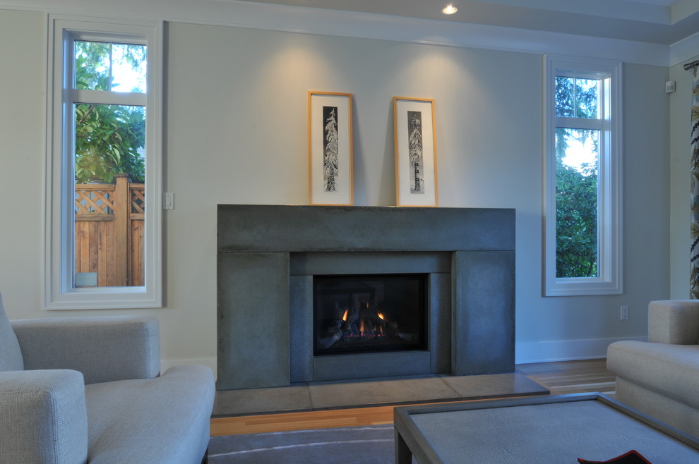 Design ideas for a medium sized traditional formal living room in Vancouver with white walls, medium hardwood flooring, a concrete fireplace surround and a standard fireplace.