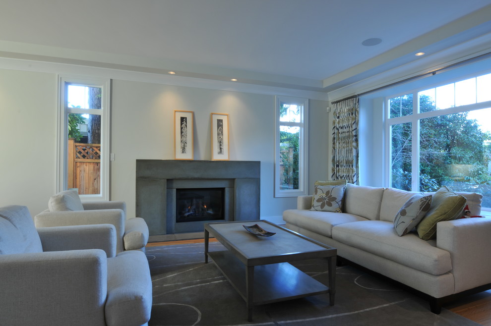 Mittelgroßes, Repräsentatives Klassisches Wohnzimmer mit weißer Wandfarbe, braunem Holzboden, Kaminumrandung aus Beton und Kamin in Vancouver