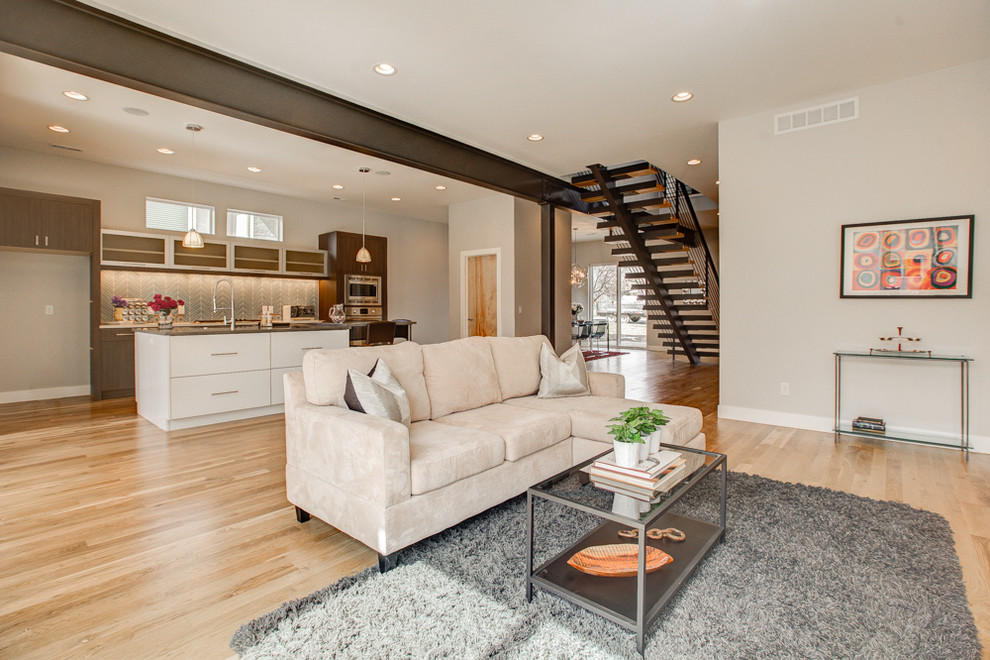 Design ideas for a large modern open plan living room in Denver with light hardwood flooring.