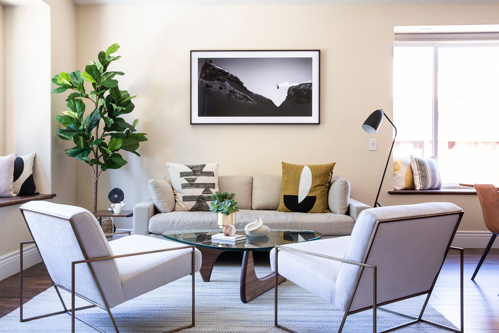 Immagine di un soggiorno minimal aperto con sala formale, pareti beige, parquet scuro e nessun camino