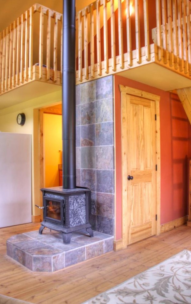 Idee per un soggiorno stile rurale con stufa a legna e cornice del camino piastrellata