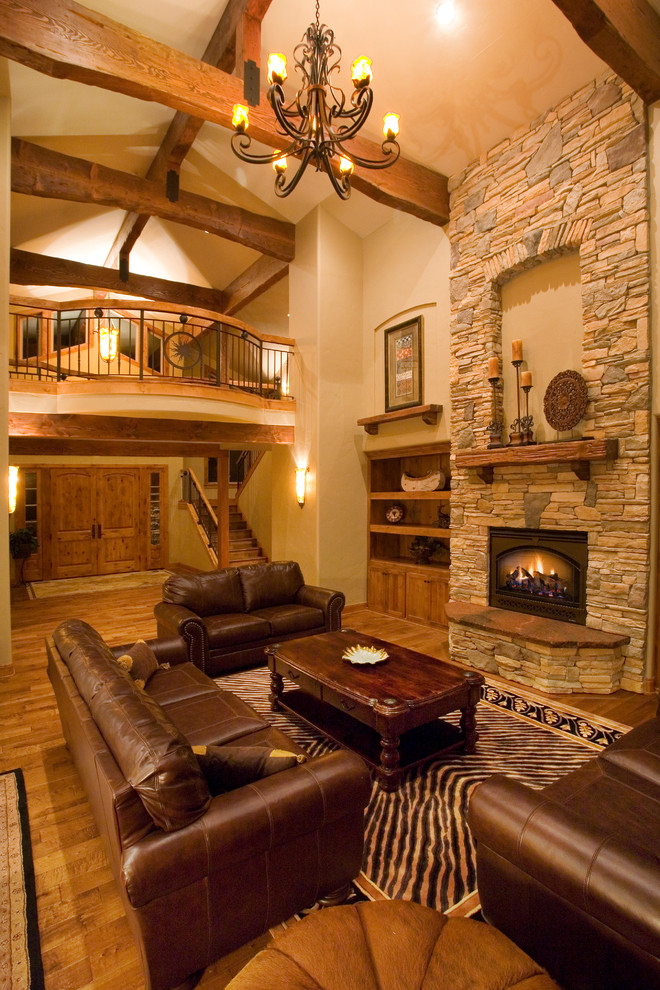 Inspiration for a large rustic open plan living room in Other with beige walls, medium hardwood flooring, a standard fireplace, a stone fireplace surround and a built-in media unit.