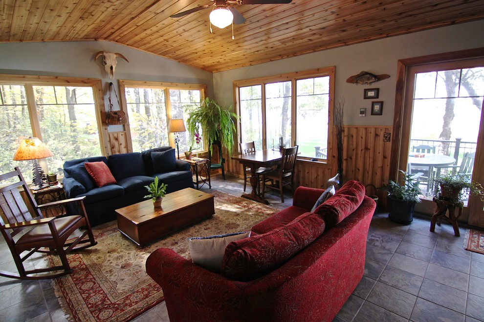 Foto de salón abierto rural de tamaño medio sin chimenea y televisor con paredes multicolor, suelo de baldosas de cerámica y suelo marrón