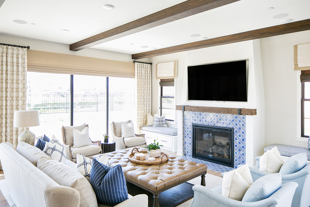 Стильный дизайн: открытая гостиная комната в морском стиле с серыми стенами, паркетным полом среднего тона, стандартным камином, фасадом камина из плитки и телевизором на стене - последний тренд