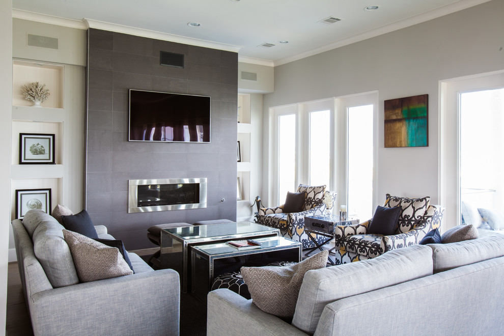 Diseño de salón para visitas costero con paredes grises, chimenea lineal y televisor colgado en la pared