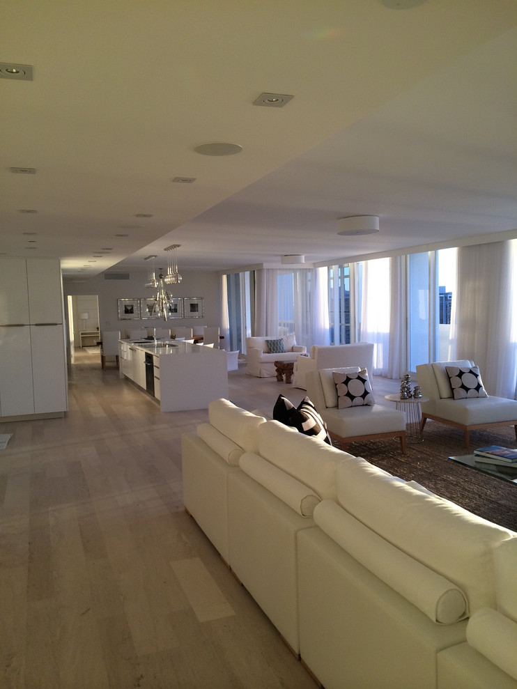 Immagine di un grande soggiorno contemporaneo aperto con angolo bar, pareti bianche, parquet chiaro e pavimento beige
