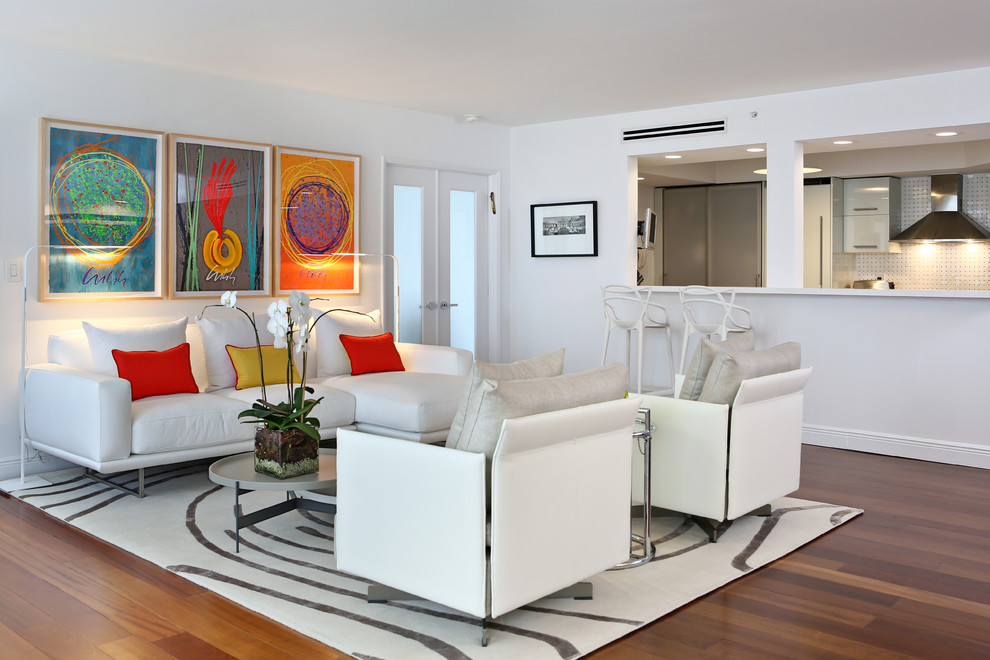 This is an example of a medium sized contemporary formal open plan living room in Miami with white walls, medium hardwood flooring, no fireplace, no tv and beige floors.
