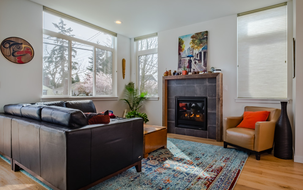 Medium sized classic formal enclosed living room in Seattle with white walls, light hardwood flooring, a standard fireplace, a stone fireplace surround, no tv and beige floors.