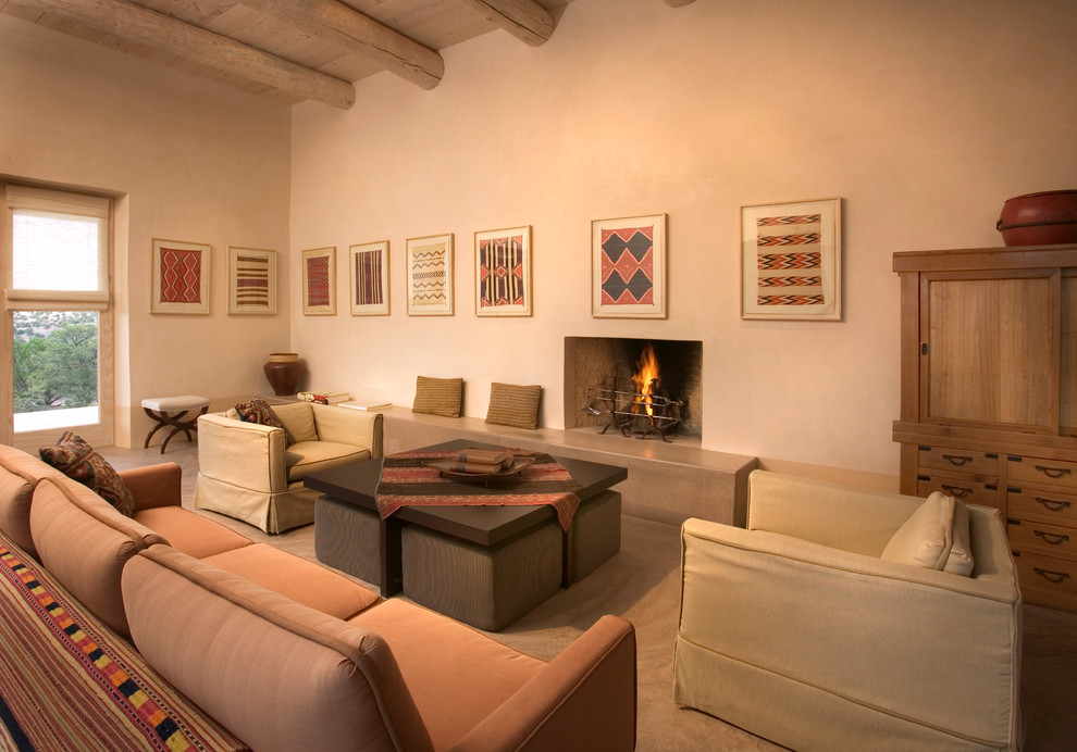 Foto de salón para visitas de estilo americano de tamaño medio con paredes beige, suelo de cemento y todas las chimeneas