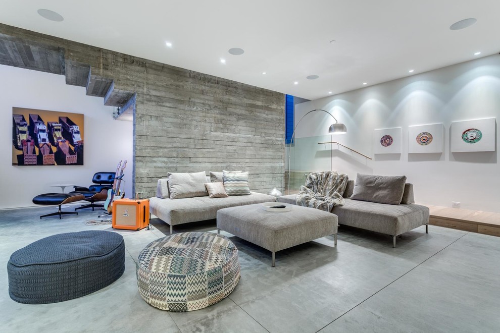 Стильный дизайн: открытая гостиная комната в современном стиле с белыми стенами, бетонным полом и серым полом - последний тренд