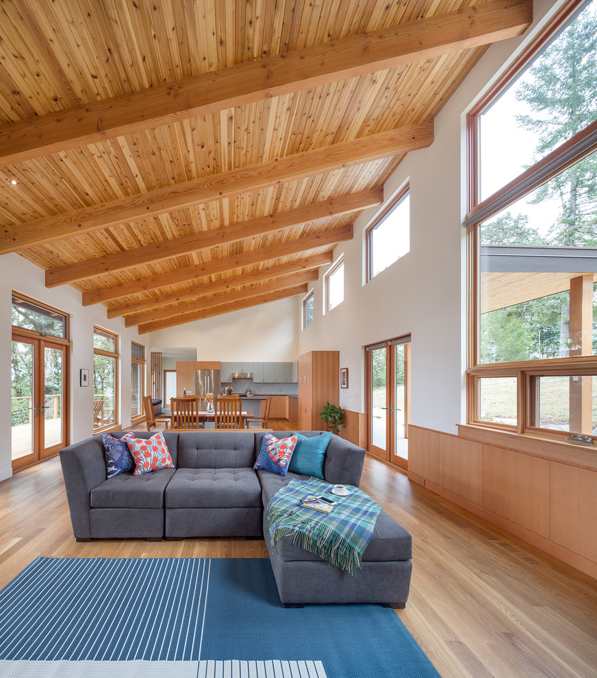 Offenes, Mittelgroßes Modernes Wohnzimmer mit hellem Holzboden, weißer Wandfarbe, Kamin und verstecktem TV in Portland